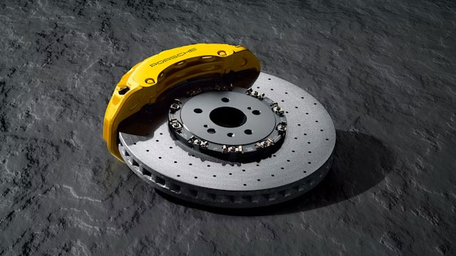 Zwei Mechaniker arbeiten an einem Porsche Fahrzeug
