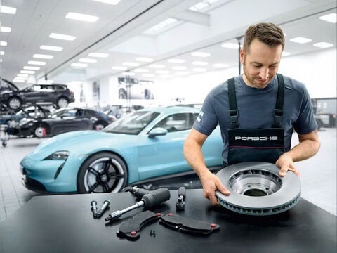 Techniker hält Teil einer Porsche Bremse.