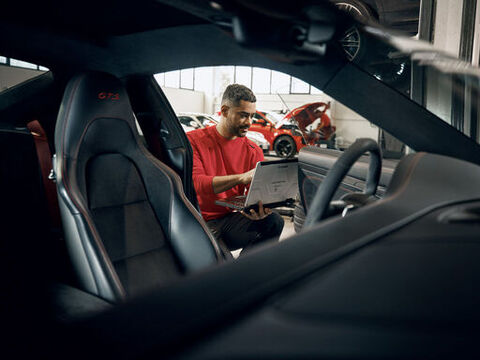 Zwei Männer stehen Blicken auf die Unterseit eines Autos auf der Hebebühne
