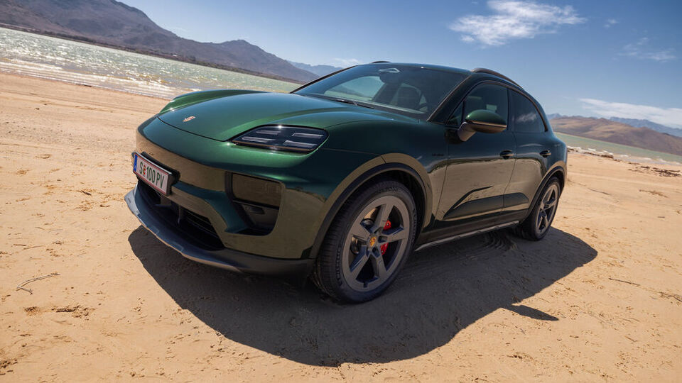 Grüner Porsche Macan am Strand mit Meer im Hintergrund