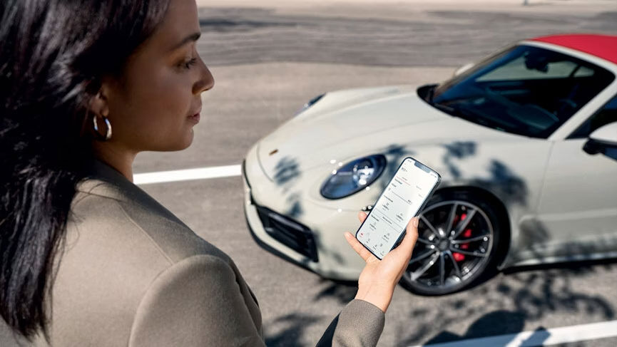 Frau bedient am Samrtphone die My Porsche app