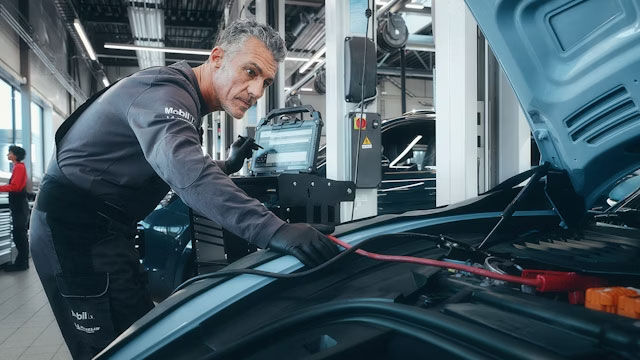 Ein Techniker arbeitet an einem Porsche Auto