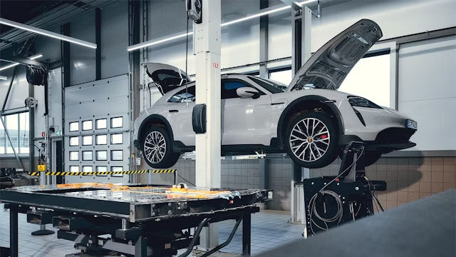 3 Personen unterhalten sich vor einem Porsche Zentrum