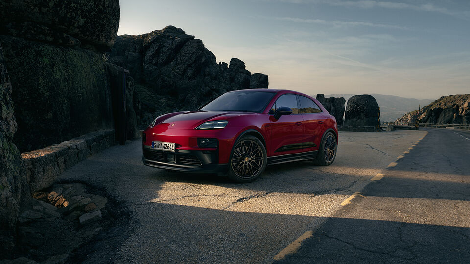 Grüner Porsche Macan am Strand mit Meer im Hintergrund